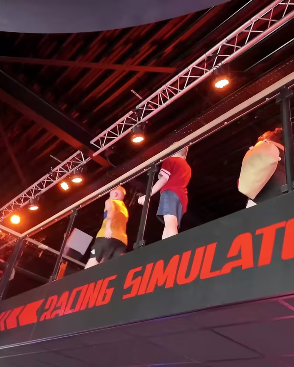 An ImSim installation under a truss sign reading racing simulators at an event.