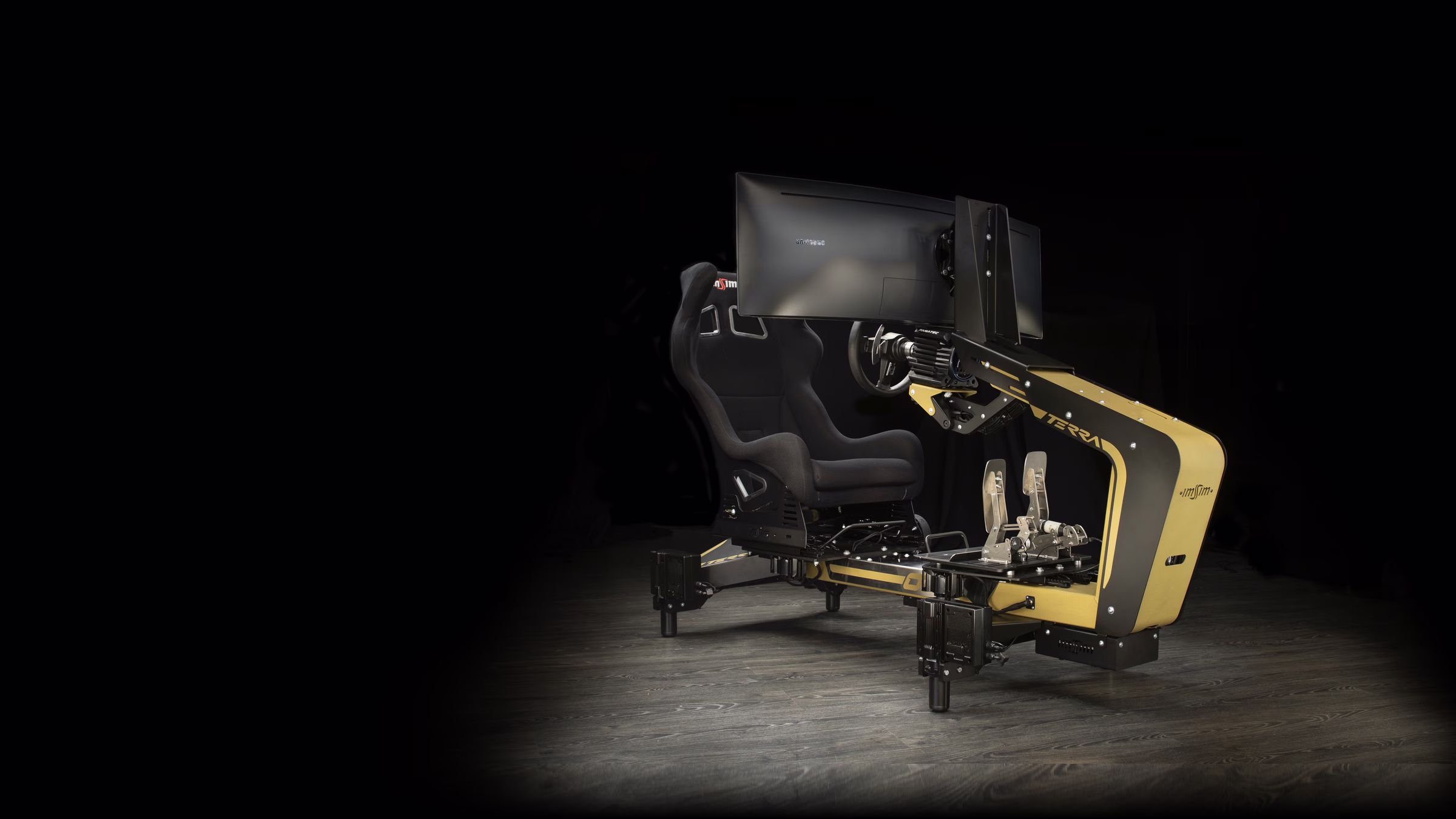 An ImSim TERRA simulator in gold and black, on four actuators, lit in a dark studio.